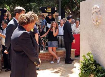 La alcaldesa Rita Barberá ayer frente al monolito, y al fondo algunos de los familiares de víctimas y heridos en el accidente.