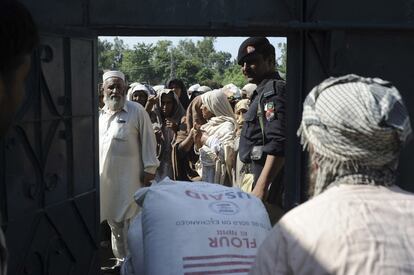 Un grupo de personas espera el reparto de ayuda en el punto de distribución del Programa Mundial de Alimentos en Daud Zai, a diez kilómetros de Peshawar.