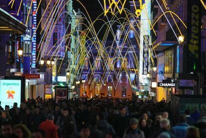 Ríos de gente bajo las luces de Navidad en calle Preciados.