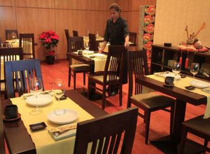 Comedor del restaurante madrileño Soy, decorado con motivos japoneses, como un casco samurái. A la derecha, un plato de <i>ikamato,</i> tartar de calamar.