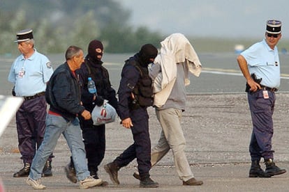 Policías franceses llevan a Mikel Antza (con la cabeza tapada) a un avión en el aeropuerto de Biarritz para su traslado a París.