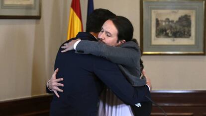 El abrazo entre Pedro Sánchez y Pablo Iglesias tras la firma del acuerdo, este martes en el Congreso.