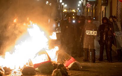 Los antidisturbios, frente a varios contenedores ardiendo.