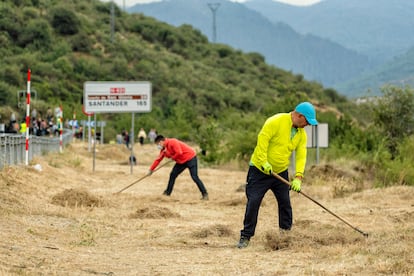 Varios vecinos limpian los márgenes de una de las carreteras de Riaño.