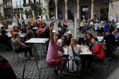 Varios turistas se fotografían un una terraza de La Habana.