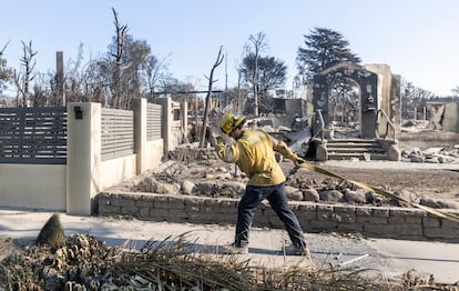 Bomberos trabajan en la zona devastada por el  incendio refrescando zonas quemadas para evitar la aparicin de nuevos fotos en Sunset Boulevard, en Los ?ngeles. 