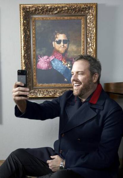 Haciéndose un selfie frente a un retrato de sí mismo.