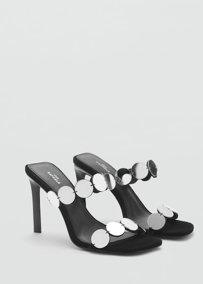 Mango se inspira en el glamour más psicodélico de los años 60 con estas sandalias con dos tiras de discos metálicos de efecto espejo y un altísimo tacón de 9,5 centímetros al alcance de las más expertas. Están confeccionadas en 100% piel y su punta tiene forma cuadrada.
