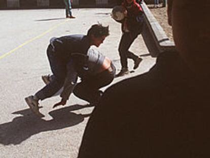Chavales jugando a pelearse en el patio de un colegio madrileño.