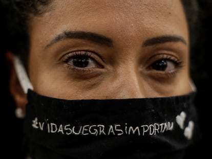 Uma mulher protesta contra o assassinato de João Alberto Silveira Freitas em um Carrefour da Barra da Tijuca, no Rio de Janeiro. Em sua máscara, lê-se: "Vidas negras importam".