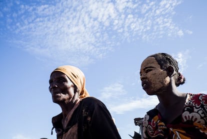 Dos mujeres hacen cola para recibir un cuenco de arroz en el pueblo de Anjampaly.