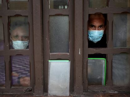 Dos pacientes con coronavirus miran por una ventana de un módulo de aislamiento del Hospital Mental Víctor Larco Herrera, en Lima (Perú).