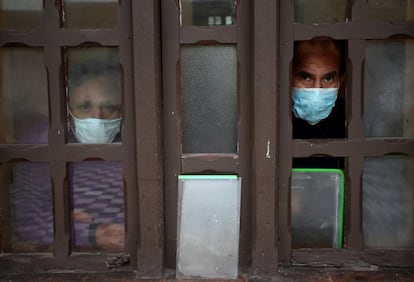Dos pacientes con coronavirus miran por una ventana de un módulo de aislamiento del Hospital Mental Víctor Larco Herrera, en Lima (Perú).