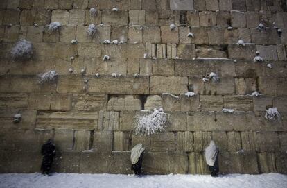 Judíos utraortodoxos rezan en el Muro de las Lamentaciones durante el temporal de nieve que azota la ciudad de Jerusalén (Israel). El país se mantiene en estado de máxima alerta por una ola de frío que ha dejado hasta el momento un manto de nieve de entre 15 y 20 centímetros de espesor en la ciudad vieja de Jerusalén.