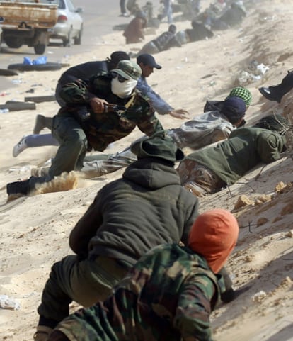 Varios rebeldes se ponen a cubierto cerca de Ajdabiya.