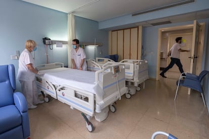 Two healthcare workers prepare a room in the Hospital Universitario Morales Meseguer in Murcia, after the last coronavirus patient there was discharged.