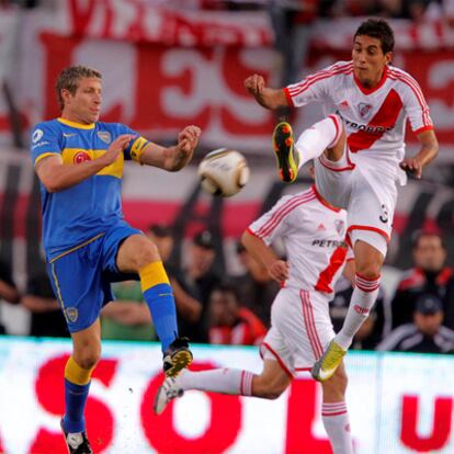 Martin Palermo y  Roberto Pereyra luchan por el balón en un encuentro entre el River y el Boca de la temporada pasada