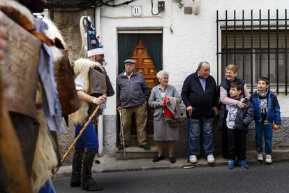 Una familia mira a los 'Zamarracos', personajes de La Vijanera de Silió (Cantabria), durante uno de los desfiles.