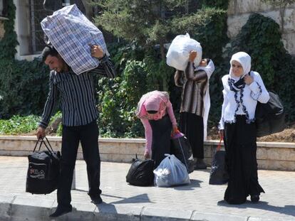 Refugiados sirios cargan con sus pertenencias en la frontera de Masnaa, entre Siria y L&iacute;bano. 