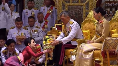 El rey Maha Vajiralongkorn de Tailandia, sentado junto a su esposa, durante la ceremonia para investir a su concubina. 