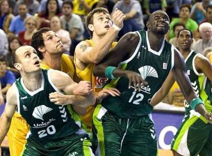 Los jugadores del Unicaja y del Gran Canaria disputan un rebote.