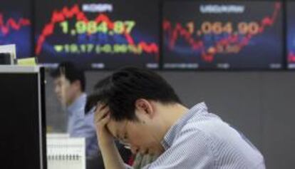 Un hombre reacciona en la sede del Korea Exchange Bank junto a unas pantallas informativas que muestran el índice Kospi en Seúl (Corea del Sur). EFE/Archivo