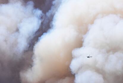 Un helicóptero atraviesa una nube de humo del incendio Washburn, sobrevolando Wawona (California), el 11 de julio.