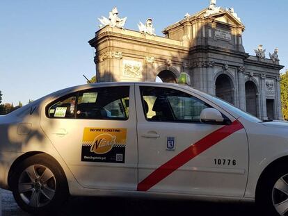 Un taxi agrupado en Ntaxi circula junto a la Puerta de Alcal&aacute;, en Madrid.