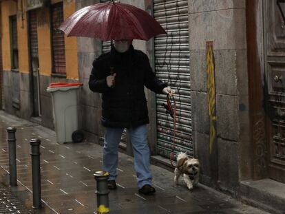 Un hombre pasea a su perro en el madrileño barrio de Malasaña.