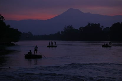 Varias balsas transportan pasajeros y mercancías a través del río Suchiate entre México y Guatemala.