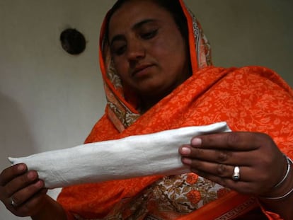 Hajra Bibi sostiene una de las compresas que fabrica en su casa.