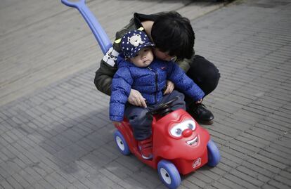 Un bebé es colocado por su madre en un cochecito infantil en Pekín (China), el 8 de marzo de 2016.