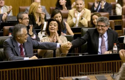 El secretario general de los socialistas y presidente andaluz, José Antonio Griñán, y el consejero de Gobernación, Francisco Pizarro, se saludan hoy en el Parlamento.