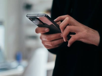 Una mujer maneja su teléfono móvil.