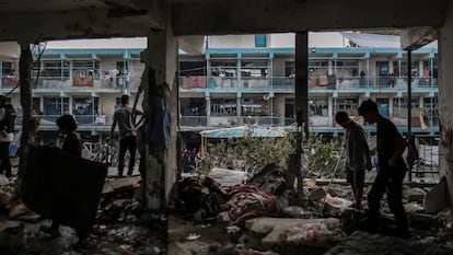 Several people search through the remains of the UNRWA school in Nuseirat, a refugee camp in central Gaza, attacked by the Israeli army.