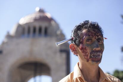 Un hombre, con un pincho de considerable tamaño clavado en el cráneo. Detrás, el monumento a la Revolución de la Ciudad de México.