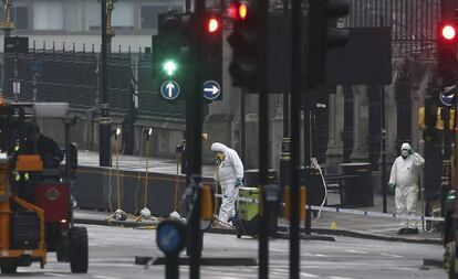 Agentes de la policía forense investigan cerca del puente Westminster Bridge el día después del atentado terrorista en Londres, el 23 de marzo de 2017.