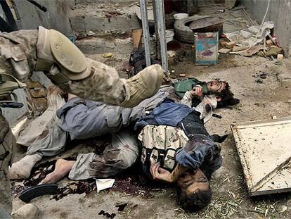 Un soldado estadounidense mueve con el pie un cadáver en una calle de Faluya en busca de armas y municiones.
