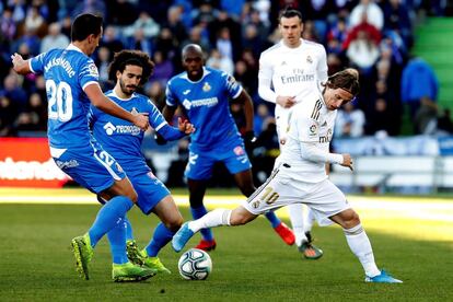 El centrocampista del Real Madrid, Luka Modric, controla el balón ante el centrocampista serbio del Getafe Nemanja Maksimovic.