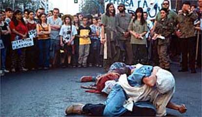 Dramatización antimilitarista durante la marcha de protesta con la celebración de l Día de las fuerzas Armadas en Alicante, ayer.