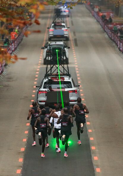 Para marcar los tiempos a los ateltas, el vehículo ha proyectado un láser que guía a los corredores. Detrás de Kipchoge, que va vestido de blanco y está el centro de la imagen, han figurado dos atletas más que, según los ensayos matemáticos, le roban cualquier turbulencia.