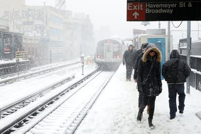 Unos usuario de tren abandonan la estación en Brooklyn.