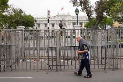 Las fuerzas de seguridad colocaron barreras para resguardar el Congreso de Perú. En la imagen, un hombre camina frente a la sede del Parlamento tras el anuncio de Castillo. 