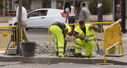 Dos obreros trabajan en la calle Arturo Soria de Madrid.