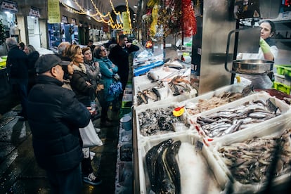 Clientes esperan a ser atendidos en una pescadera del Mercado de Abastos de Santiago de Compostela (A Coru?a), este viernes.