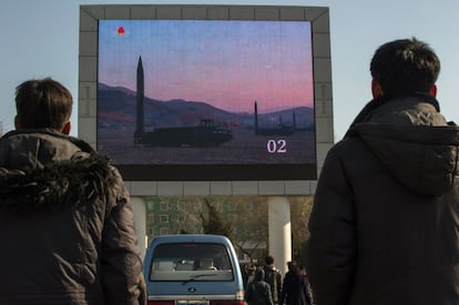 Varios ciudadanos ven las imágenes de un lanzamiento de misiles en una pantalla grande fuera de la estación de trenes de Pyongyang.