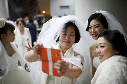 Un grupo de novias se hacen un selfi durante el descanso de una boda multitudinaria celebrada en Gapyeong (Coreal del Sur), el 20 de febrero de 2016.