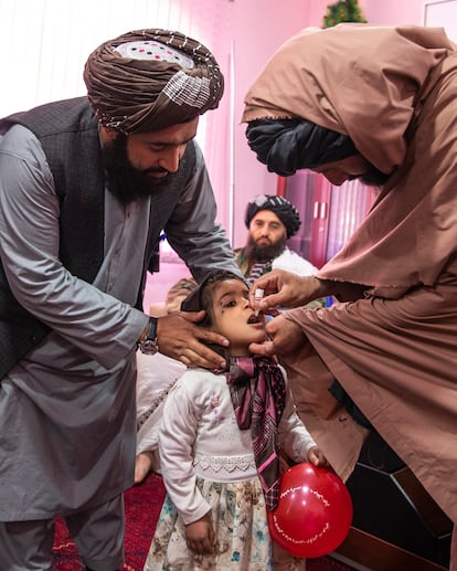 El vicegobernador de Badghis, Mohibullah Asad, ayuda a administrar la vacuna de la polio a una niña.