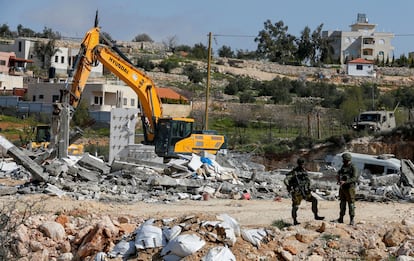 Soldados israelíes vigilan la demolición de un edificio palestino, el lunes en Bani Naim (Cisjordania).