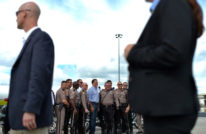 El candidato republicano se fotografía con policías en el aeropuerto de Orlando, antes de tomar su avión de campaña, el 7 de octubre.
